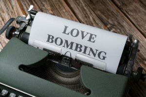 Machine à écrire avec un message de love bombing, symbolisant une stratégie manipulatrice déguisée en romantisme