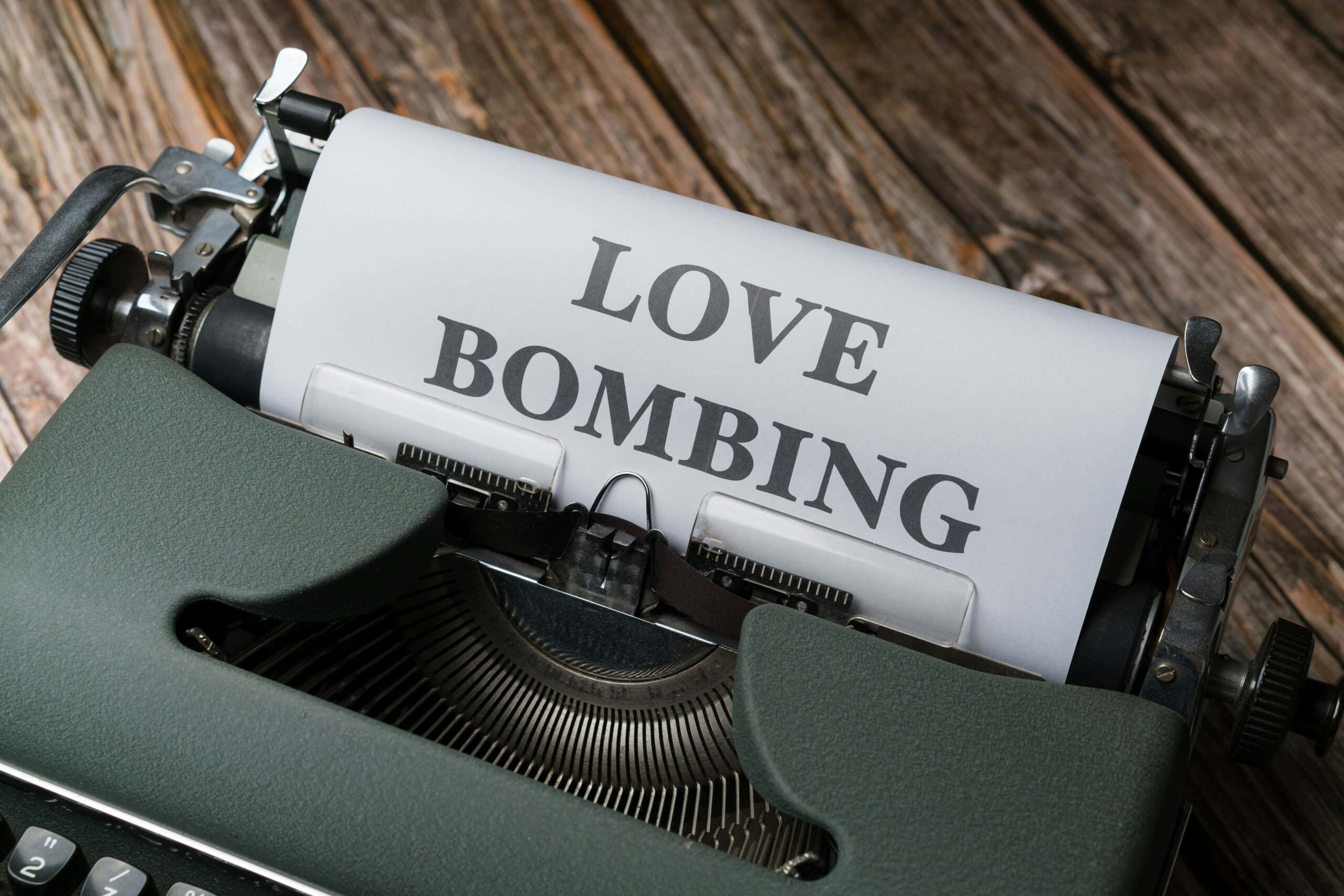Machine à écrire avec un message de love bombing, symbolisant une stratégie manipulatrice déguisée en romantisme