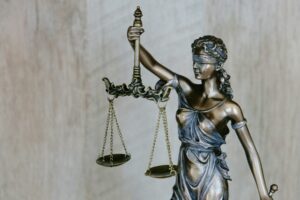 Femme tenant une statue de justice avec une épée, symbole de combat contre l'injustice